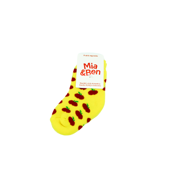 Vollbild der Apfel Socken in Kindergröße. Gelder Hintergrund mit roten Äpfel. Schild an der Socke zeigt das Logo Mia&Ben