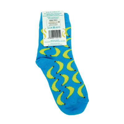 Vollbild der blauen Kindersocken mit Bananenmuster. Oben an der Socke ist ein Schild auf der ein Barcode, sowie allgemeine Infos über die Socken.