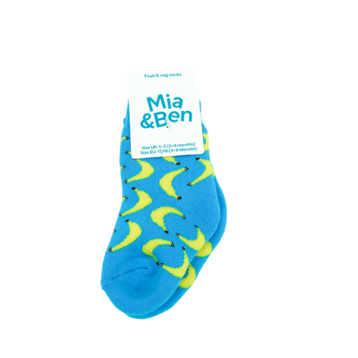 Vollbild der blauenKindersocken mit Bananenmuster. Oben an der Socke ist ein Schild auf der das Logo von Ben&Anna ist.